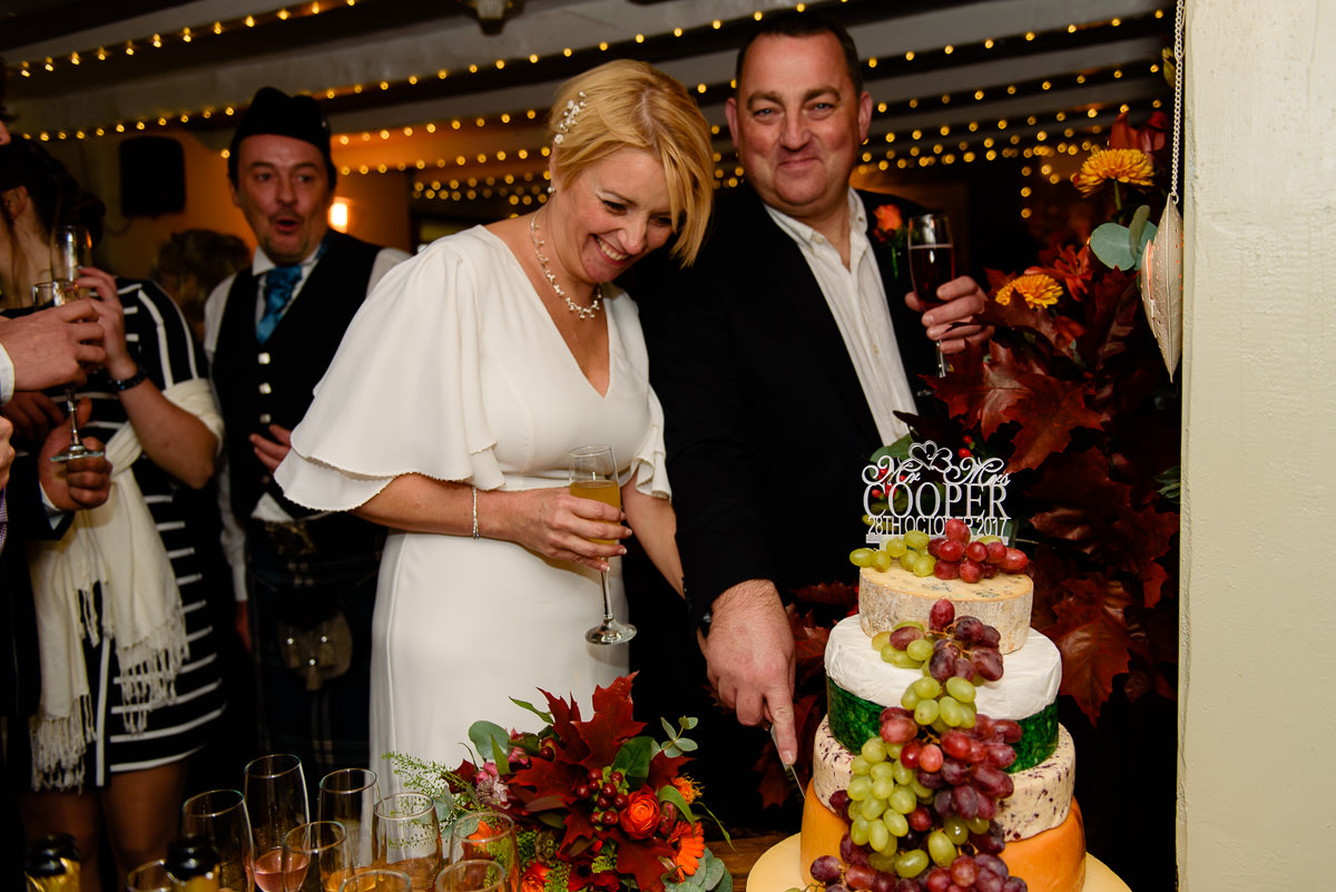 bride and groom cutting cake of cheese